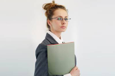 A woman in glasses holding a folder